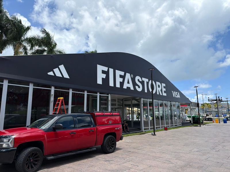 Large printed canopy awning reading FIFA Store with Adidas and Visa branding over a retail tent entrance